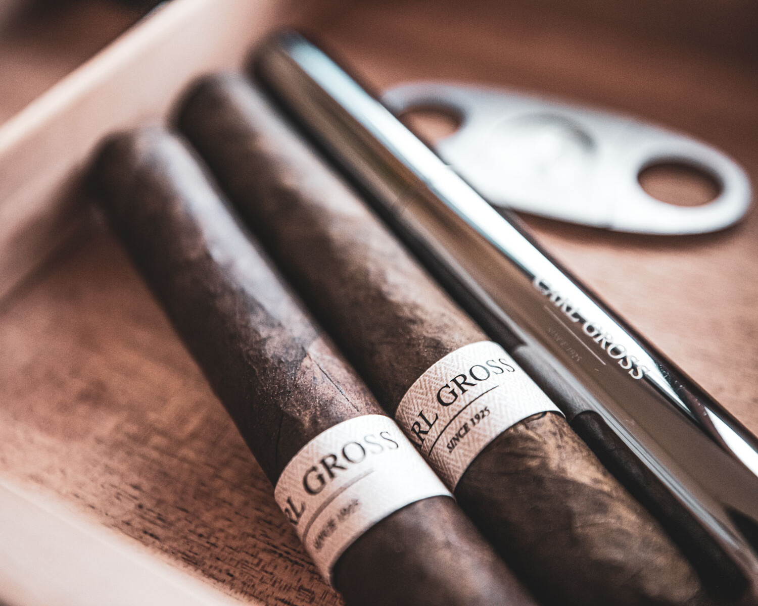 Handgerollte Zigarren mit Zigarrenschneider auf Tisch