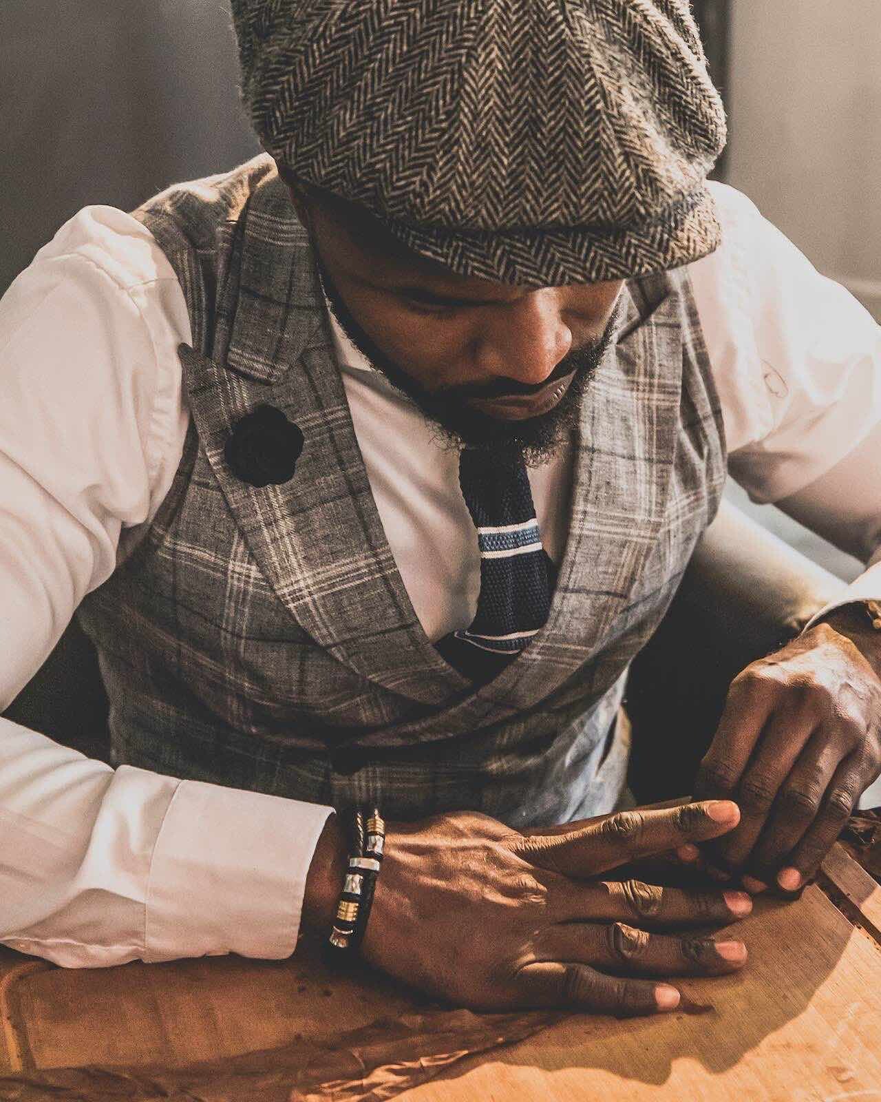 Zigarrendreher fertigt handgerollte Zigarre am Tisch